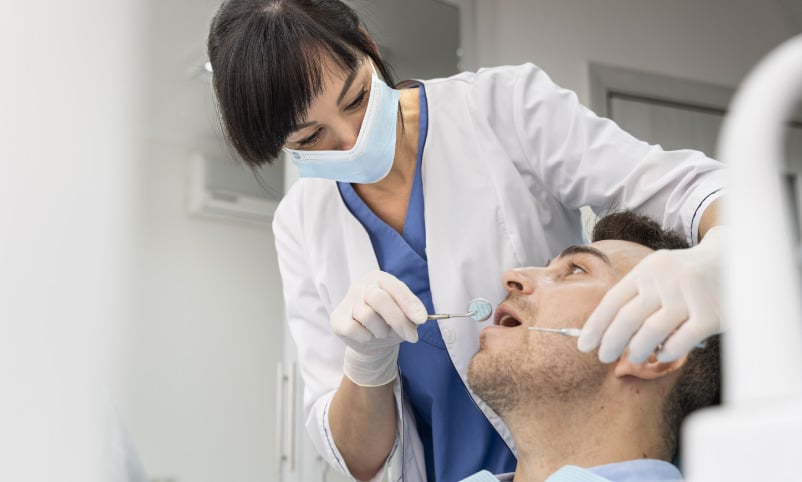 A dentist is examining a patient's teeth.