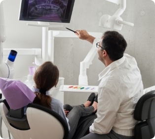 A man and a woman sitting in a dental chair.
